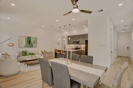 Wide view of the living and dining area toward the entry hallway