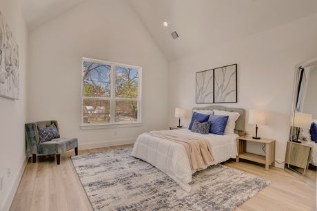 Primary bedroom with vaulted ceiling and blue accent pillows