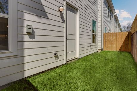 Side exterior and fenced backyard of an Archers Villas townhome