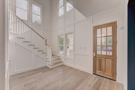 Two-story entry foyer at the Stephan Custom Residence with a wood front door