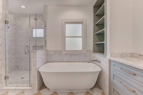 Primary bathroom with soaking tub and glass shower at the Stephan Custom Residence