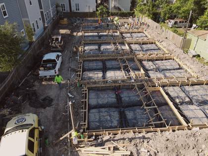 Aerial view of poured concrete foundations with framing beginning at Residences on 24th
