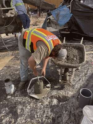 Crew member performing a concrete slump test at Mockingbird Place