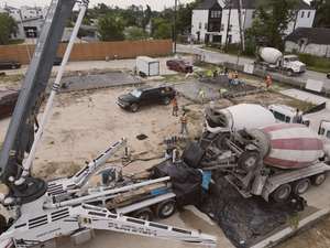 Aerial view of a concrete truck pouring a foundation slab at Mockingbird Place