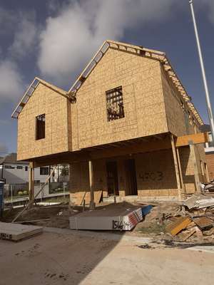 Wood-framed duplex under construction with twin gables at Mockingbird Place